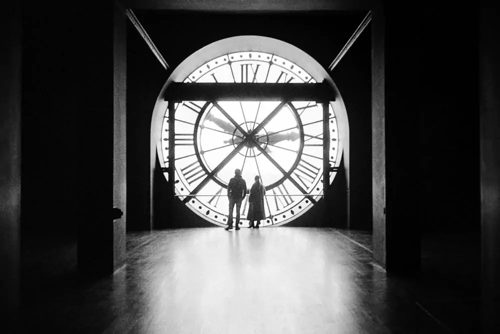 Silhouettes in front of the clock of Orsay Museum in Paris 